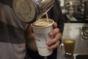 barista pouring a latte